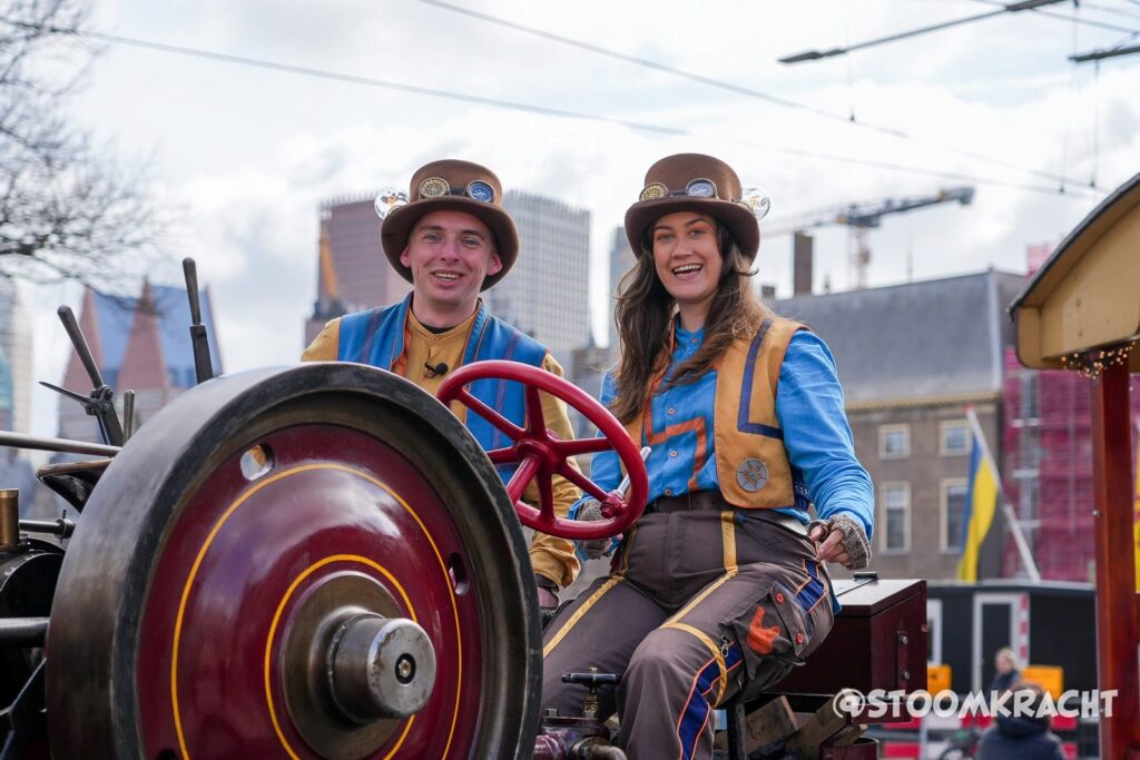 Twee medewerkers van Drievliet op de stoomtractor tijdens de promotierit in Den Haag
